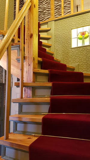 Tapeten im Flur tapeziert und Treppe mit rotem Teppichboden belegt