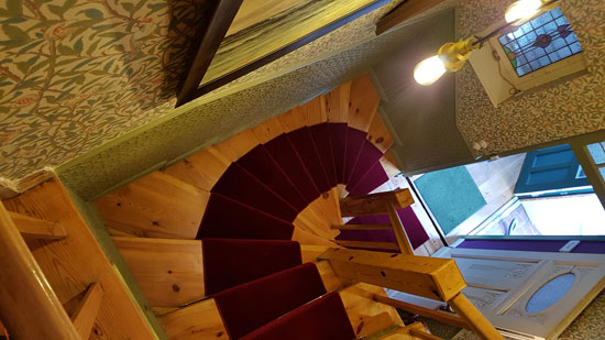 Tapete im Flur tapeziert und Treppenstufen mit rotem Teppichboden belegt